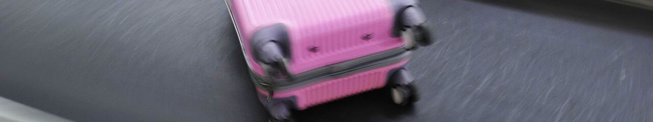 Purple suitcase on a baggage conveyor belt